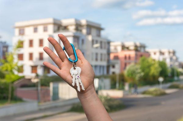 Real estate agent giving house key to a new property owner