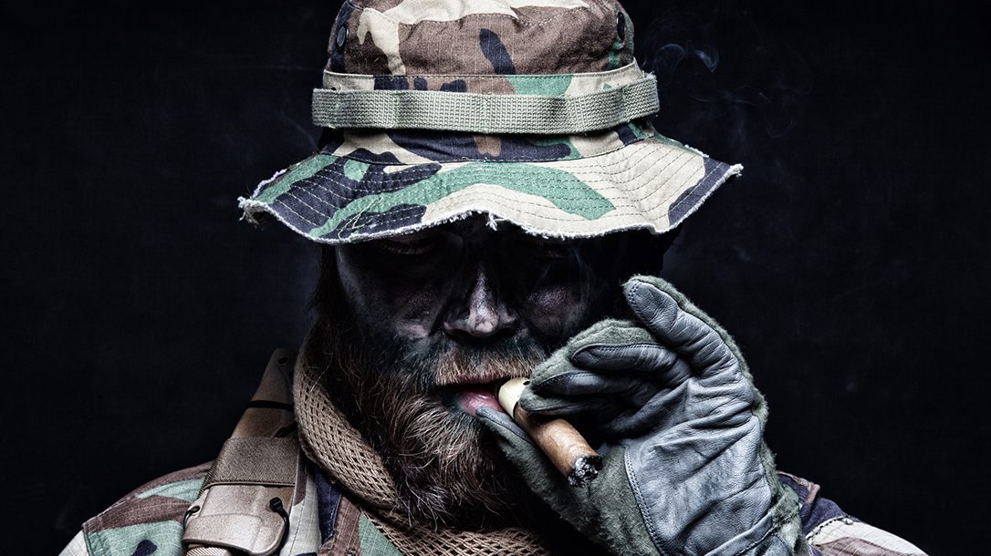 Commando soldier in boonie hat smoking cigar